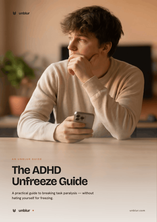 Person sitting at a table holding a phone with 'The ADHD Unfreeze Guide' text overlay.